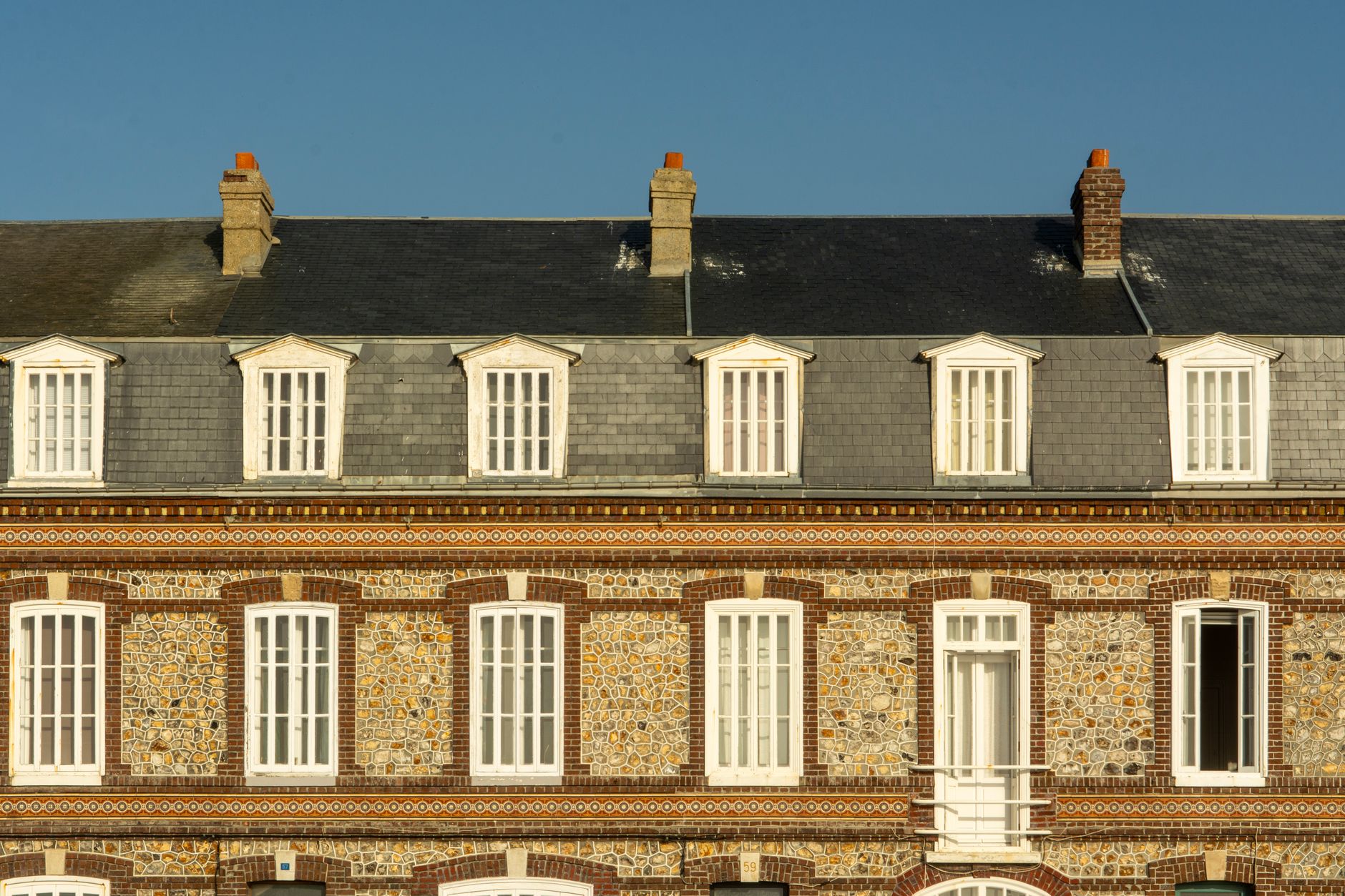 Façade normande en brique et silex sous une couverture d'ardoise à Fécamp