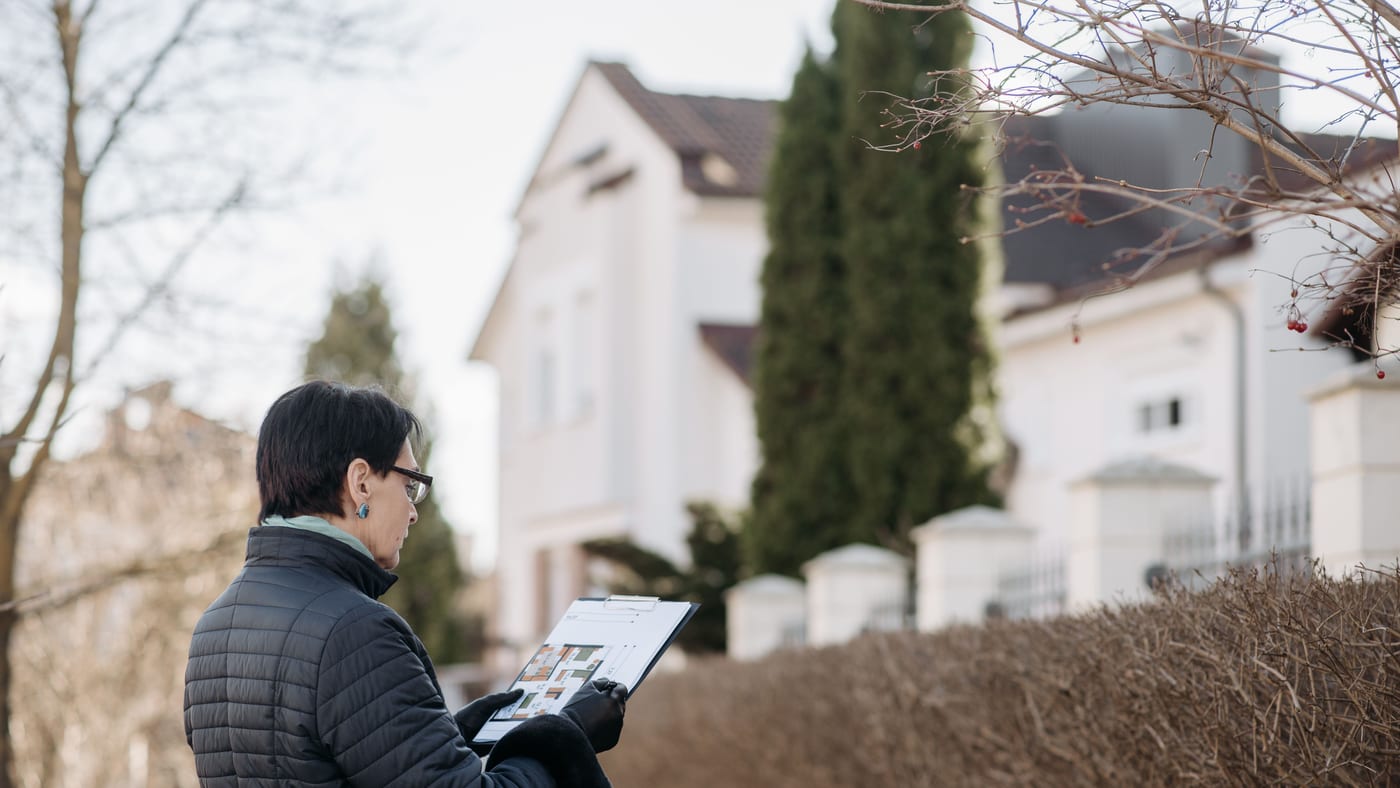Auditeur relevant les caractéristiques d'une maison sur tablette lors d'un audit énergétique sur site