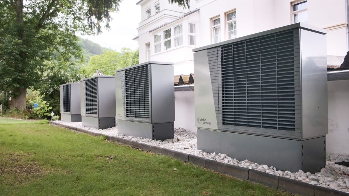 Rangée d'unités extérieures de pompes à chaleur installées devant un immeuble