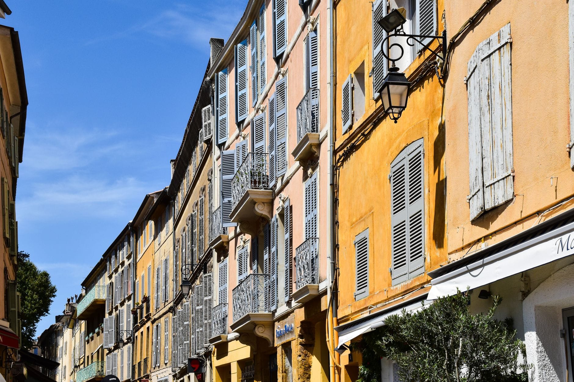 Rue du centre ancien d'Aix-en-Provence bordée d'immeubles à persiennes