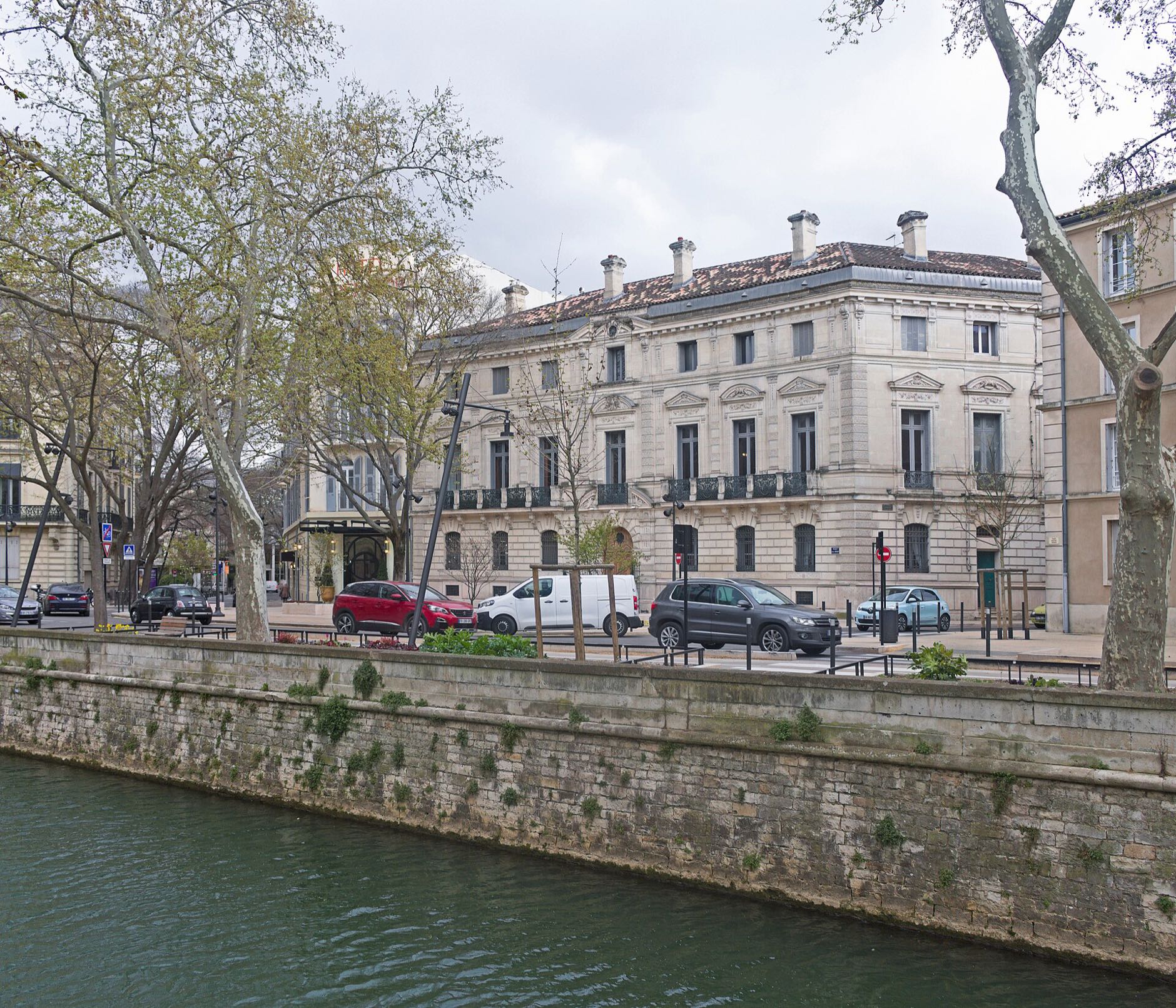 Immeuble en pierre bordant le canal, place Aristide Briand à Nîmes