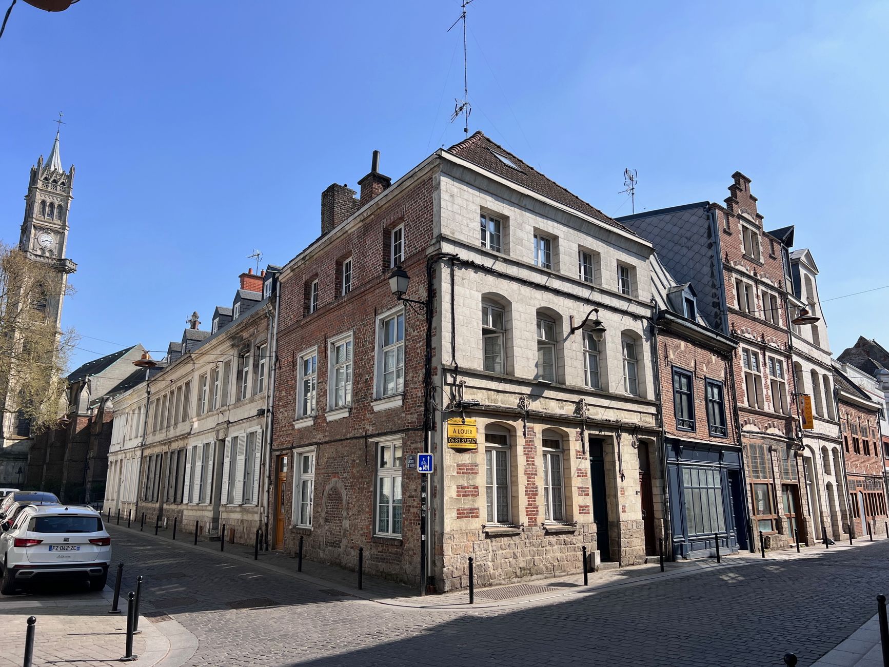 Immeuble ancien en brique et pierre à un angle de rue de Valenciennes